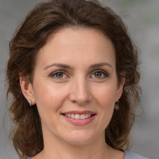 Joyful white young-adult female with medium  brown hair and green eyes