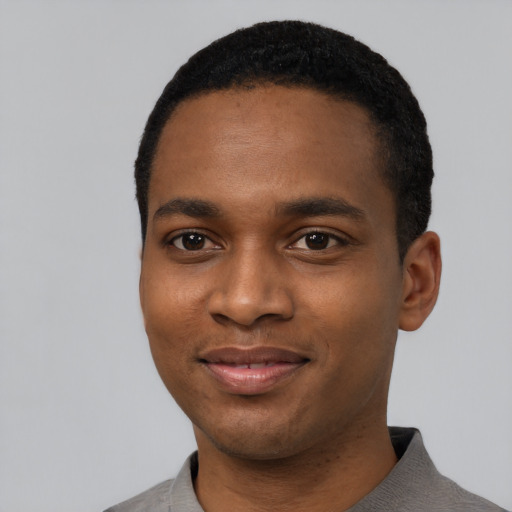 Joyful black young-adult male with short  black hair and brown eyes