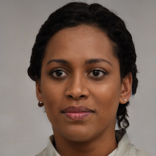 Joyful black young-adult female with short  black hair and brown eyes