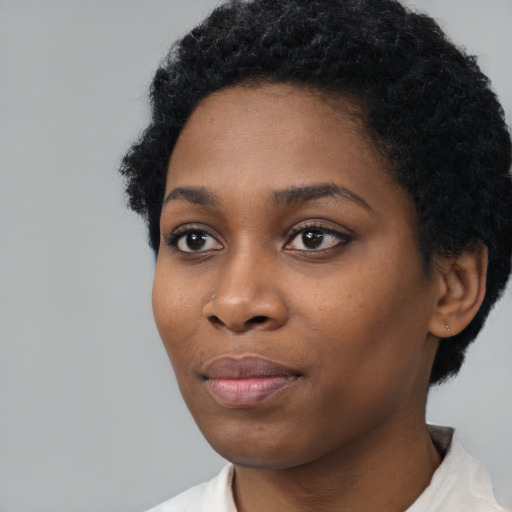 Joyful black young-adult female with short  black hair and brown eyes