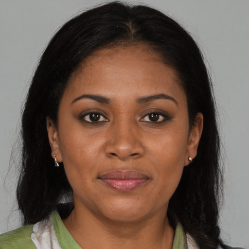 Joyful black young-adult female with long  brown hair and brown eyes