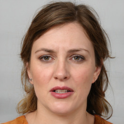 Joyful white adult female with medium  brown hair and blue eyes