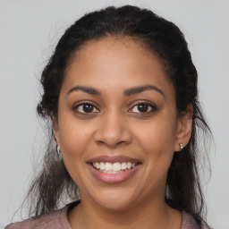 Joyful latino young-adult female with long  brown hair and brown eyes