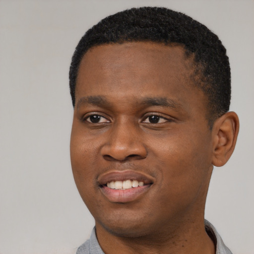 Joyful black young-adult male with short  black hair and brown eyes