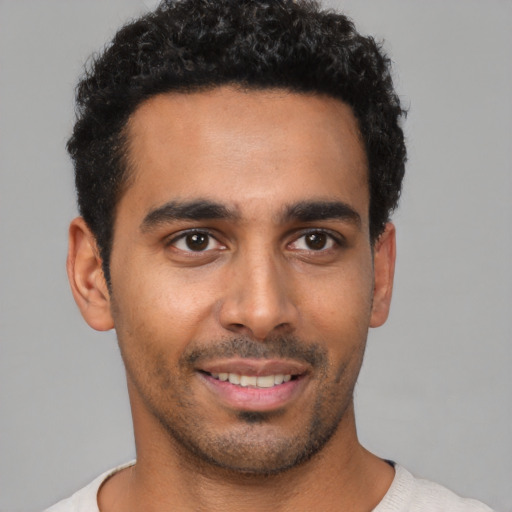 Joyful latino young-adult male with short  black hair and brown eyes