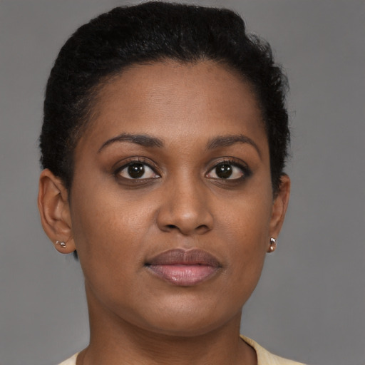 Joyful black young-adult female with short  brown hair and brown eyes