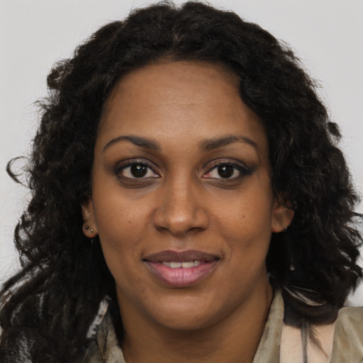 Joyful black adult female with long  brown hair and brown eyes