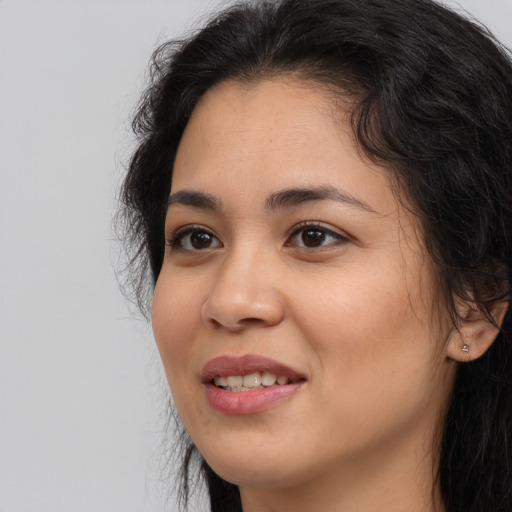 Joyful latino young-adult female with long  brown hair and brown eyes