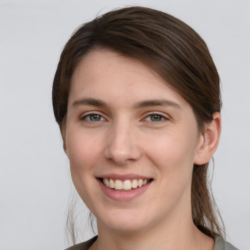 Joyful white young-adult female with medium  brown hair and grey eyes