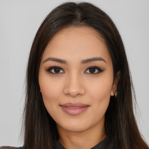 Joyful latino young-adult female with long  brown hair and brown eyes