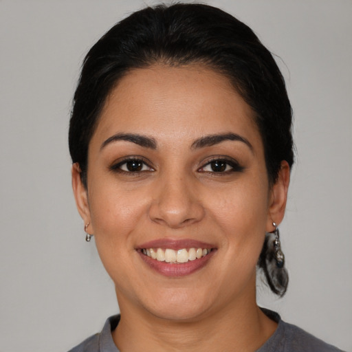 Joyful latino young-adult female with medium  brown hair and brown eyes