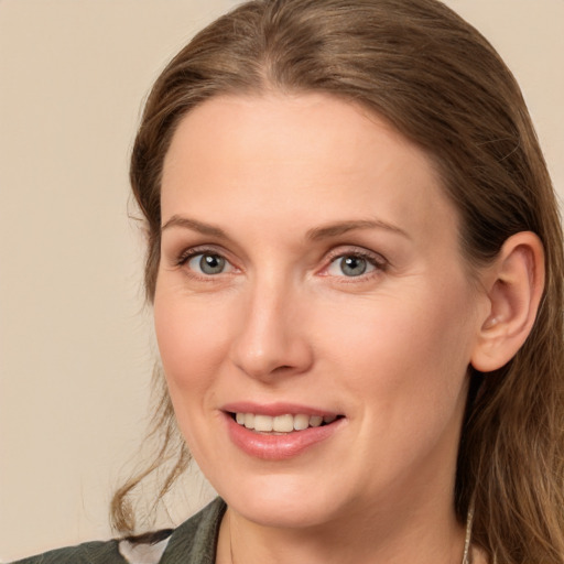 Joyful white young-adult female with long  brown hair and blue eyes