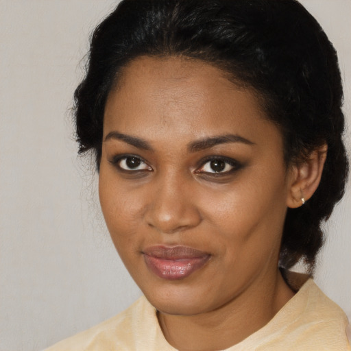 Joyful black young-adult female with medium  black hair and brown eyes