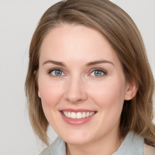 Joyful white young-adult female with medium  brown hair and blue eyes