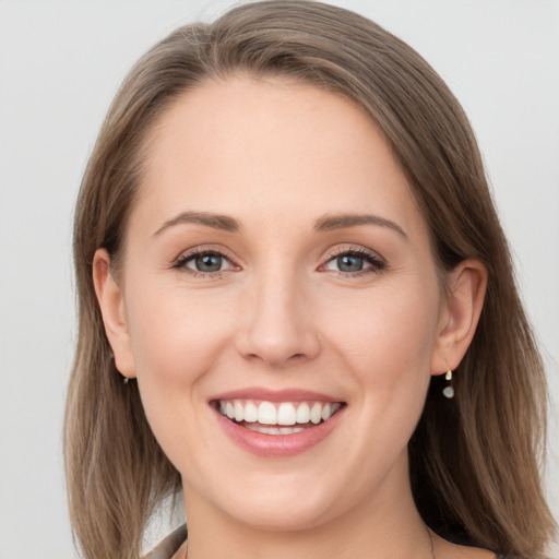 Joyful white young-adult female with long  brown hair and grey eyes