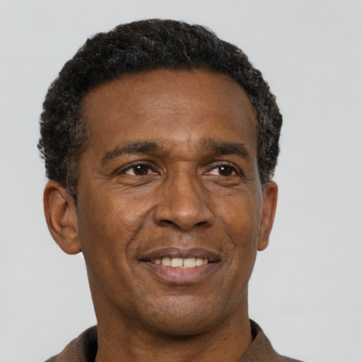 Joyful black adult male with short  black hair and brown eyes