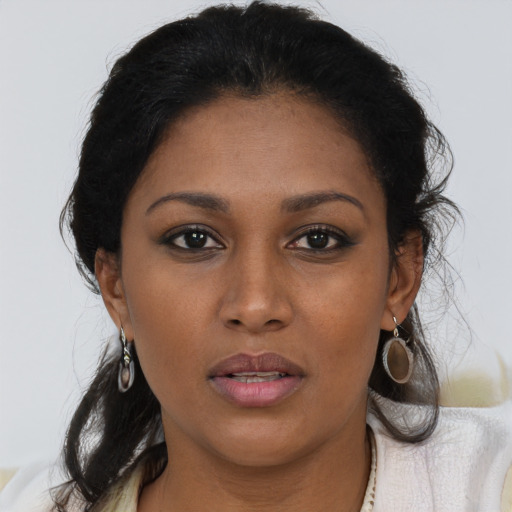 Joyful black young-adult female with long  brown hair and brown eyes