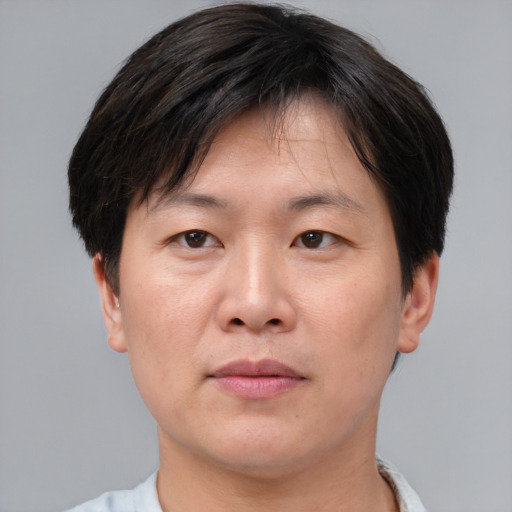 Joyful asian adult male with short  brown hair and brown eyes