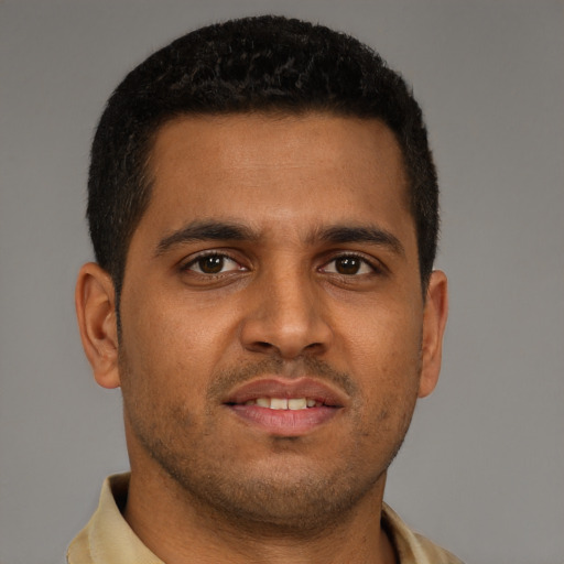 Joyful black young-adult male with short  brown hair and brown eyes