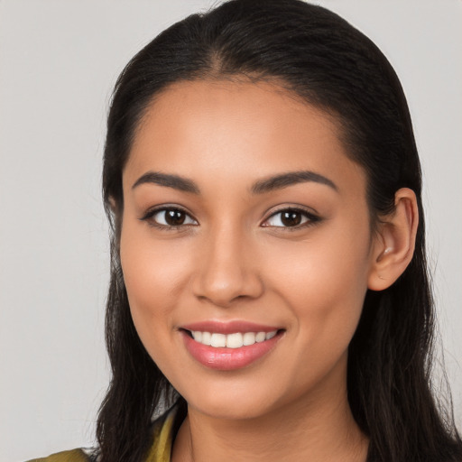 Joyful latino young-adult female with long  brown hair and brown eyes