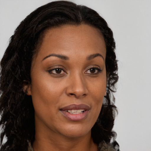 Joyful black young-adult female with long  brown hair and brown eyes