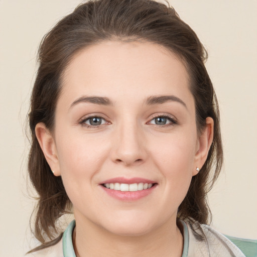 Joyful white young-adult female with medium  brown hair and grey eyes