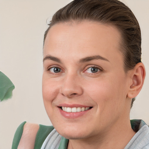 Joyful white young-adult female with short  brown hair and green eyes