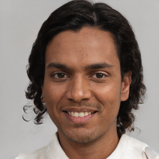 Joyful white young-adult male with medium  black hair and brown eyes