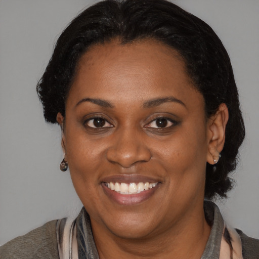 Joyful black adult female with medium  brown hair and brown eyes