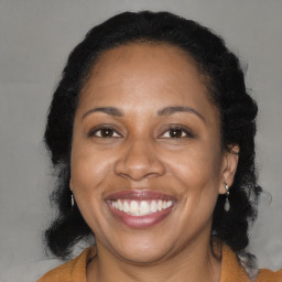 Joyful black adult female with long  brown hair and brown eyes