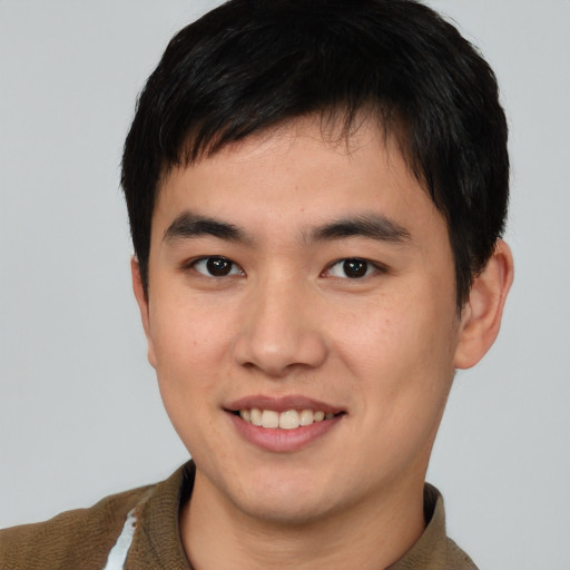 Joyful asian young-adult male with short  brown hair and brown eyes