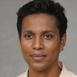 Joyful black adult female with short  brown hair and brown eyes