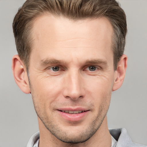 Joyful white adult male with short  brown hair and grey eyes