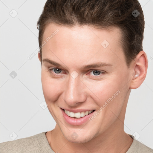 Joyful white young-adult male with short  brown hair and grey eyes