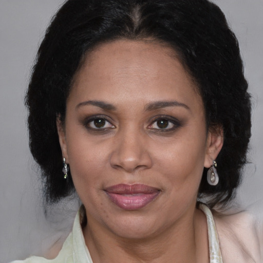 Joyful black adult female with medium  brown hair and brown eyes