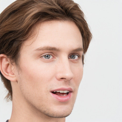 Joyful white young-adult male with short  brown hair and blue eyes