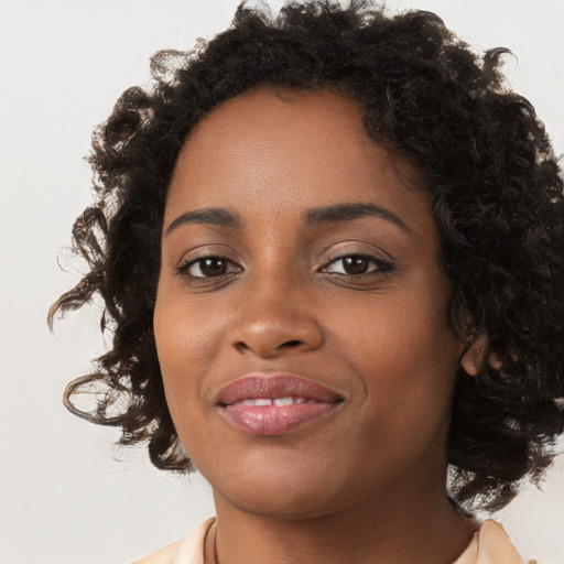 Joyful black young-adult female with long  brown hair and brown eyes