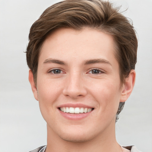 Joyful white young-adult female with short  brown hair and grey eyes