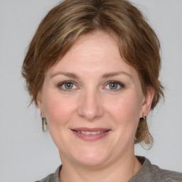 Joyful white adult female with medium  brown hair and grey eyes