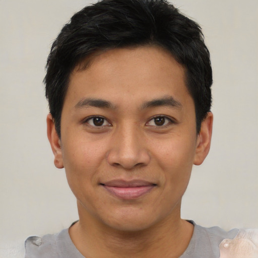 Joyful asian young-adult male with short  black hair and brown eyes