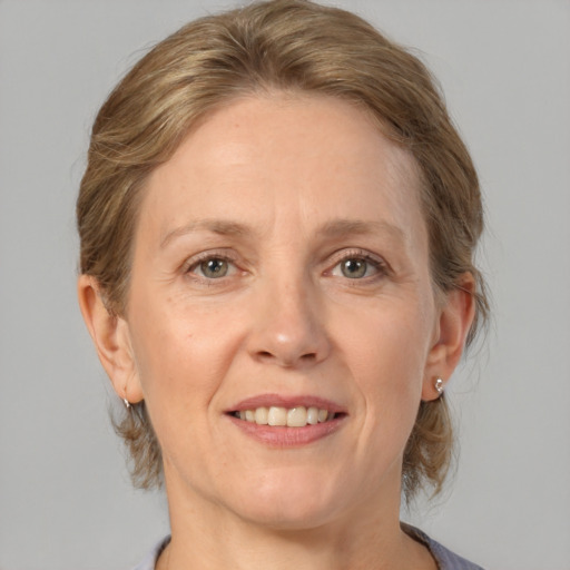 Joyful white adult female with medium  brown hair and grey eyes