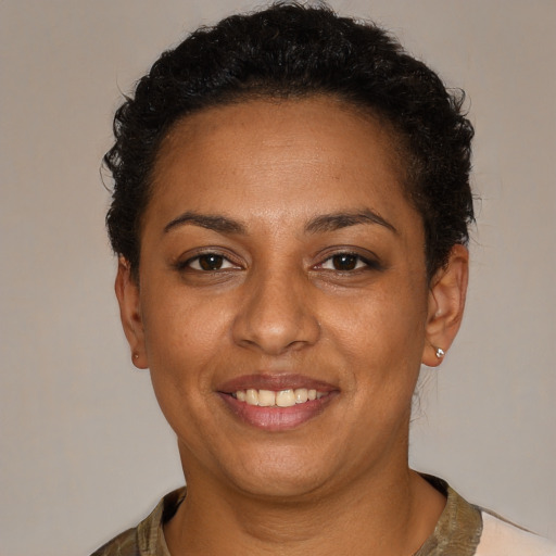 Joyful black young-adult female with short  brown hair and brown eyes