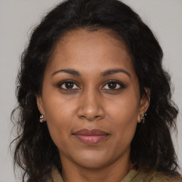 Joyful black adult female with long  brown hair and brown eyes