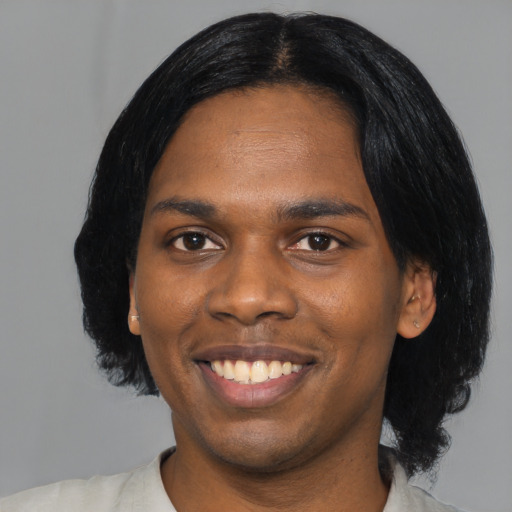Joyful black young-adult male with medium  black hair and brown eyes