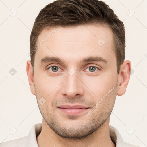 Joyful white young-adult male with short  brown hair and grey eyes