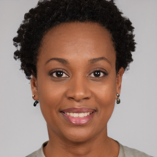 Joyful black young-adult female with short  black hair and brown eyes
