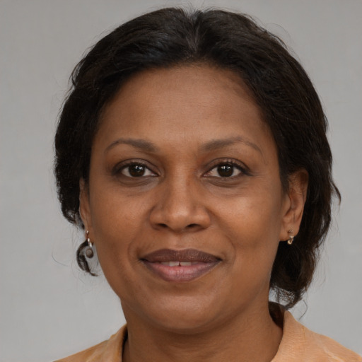 Joyful black adult female with medium  brown hair and brown eyes