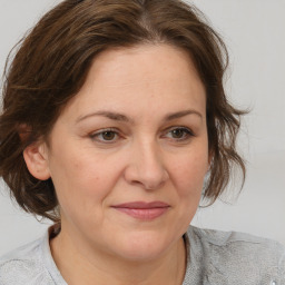 Joyful white adult female with medium  brown hair and blue eyes