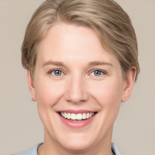 Joyful white young-adult female with short  brown hair and blue eyes