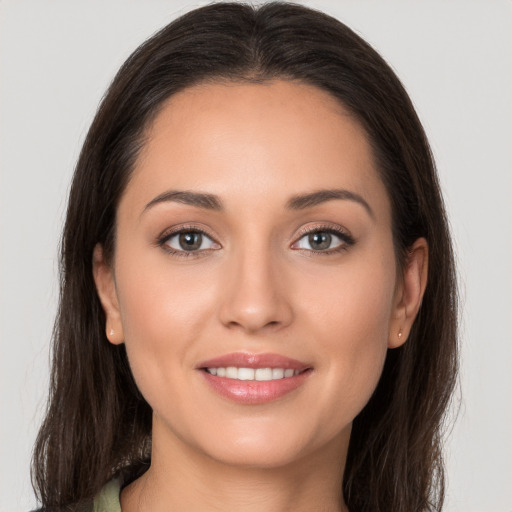 Joyful white young-adult female with long  brown hair and brown eyes